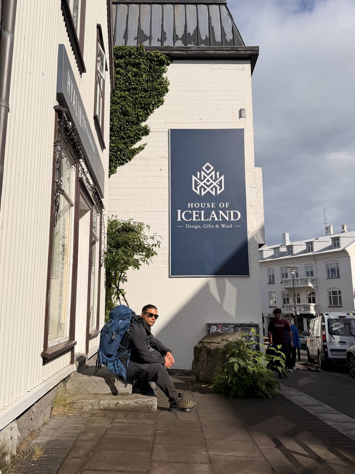 Resting outside House of Iceland with trekking pack, Reykjavik