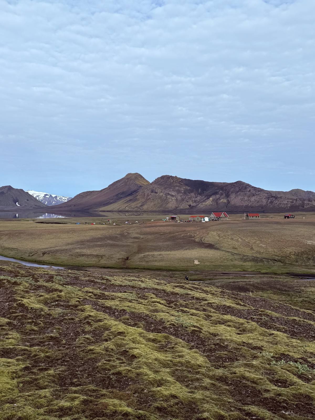 Wide valley view with mountain huts in the distance